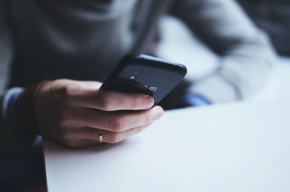Person checking a budget on a smartphone at a kitchen table
